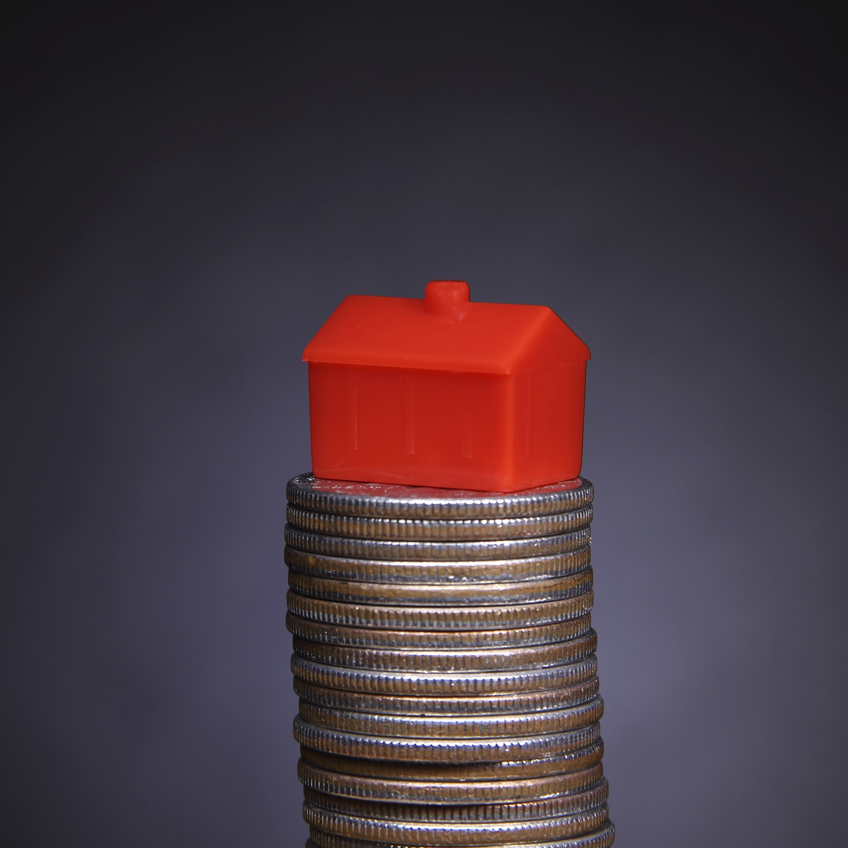 alt="house on stack of coins"